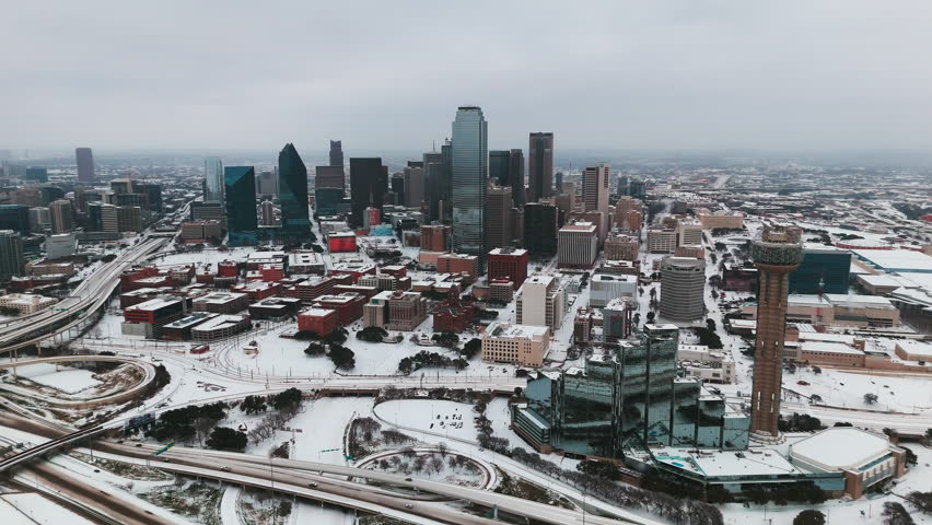 Wide aerial of Dallas, Texas covered in snow during winter storm. 