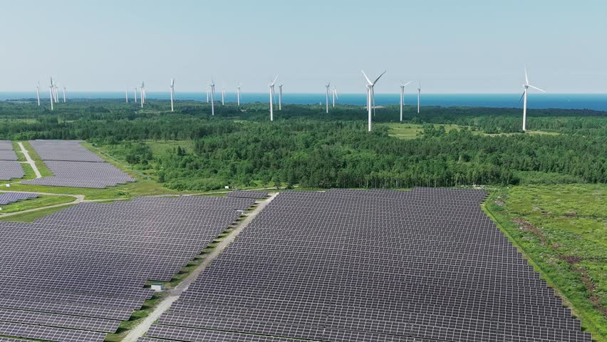 Aerial drone footage of wind turbines and solar panels at a renewable energy plant in a natural landscape near Paldiski, Estonia.