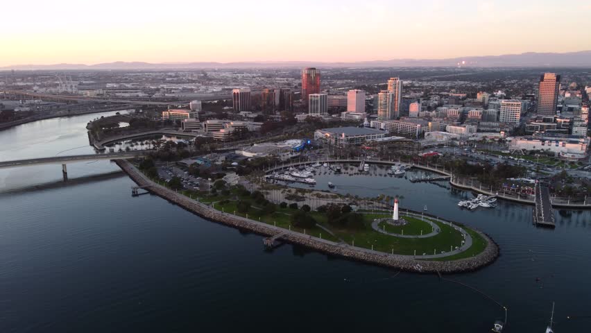 Downtown Long Beach. Waterfront skyline, Shoreline park and Bridge, Rainbow Harbor marina, Aquarium, Lighthouse tower and Convention Center at sunset.