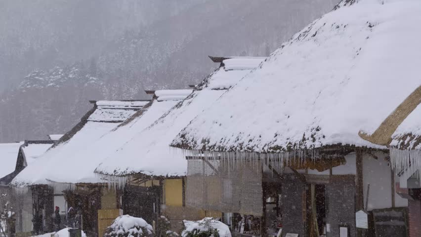 Typical straw roof houses at Ouchi Juku in Fukushima with slow falling snow