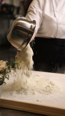 The cook in the kitchen is preparing dough for dumplings.