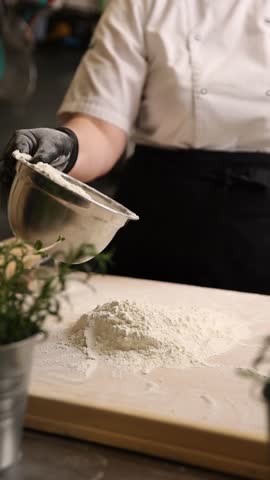 The cook in the kitchen is preparing dough for dumplings.