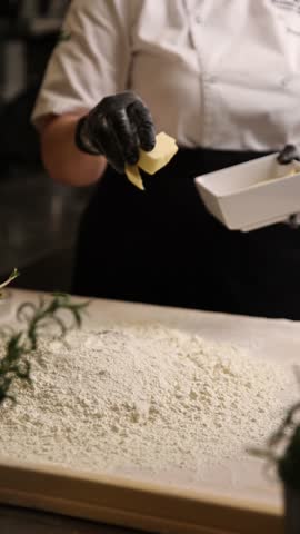 The cook in the kitchen is preparing dough for dumplings.