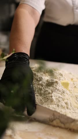 The cook in the kitchen is preparing dough for dumplings.
