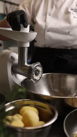 The cook in the kitchen prepares the filling for the dumplings.