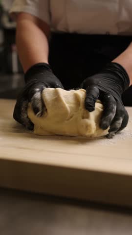 The cook in the kitchen is preparing dough for dumplings.