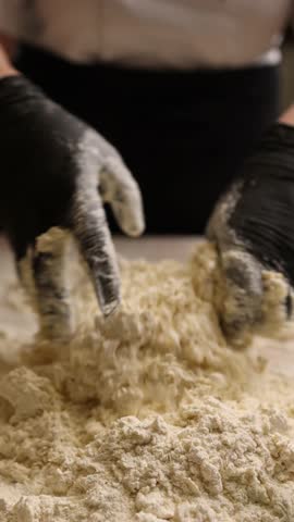 The cook in the kitchen is preparing dough for dumplings.