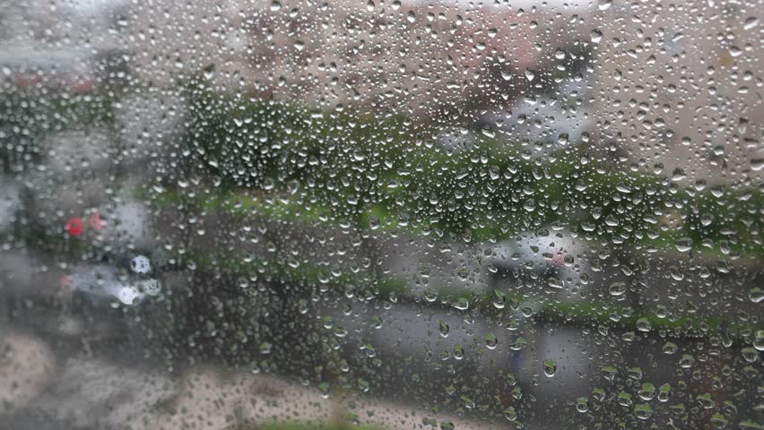 Winter in Lisbon, raindrops on the window and cars driving on the road.