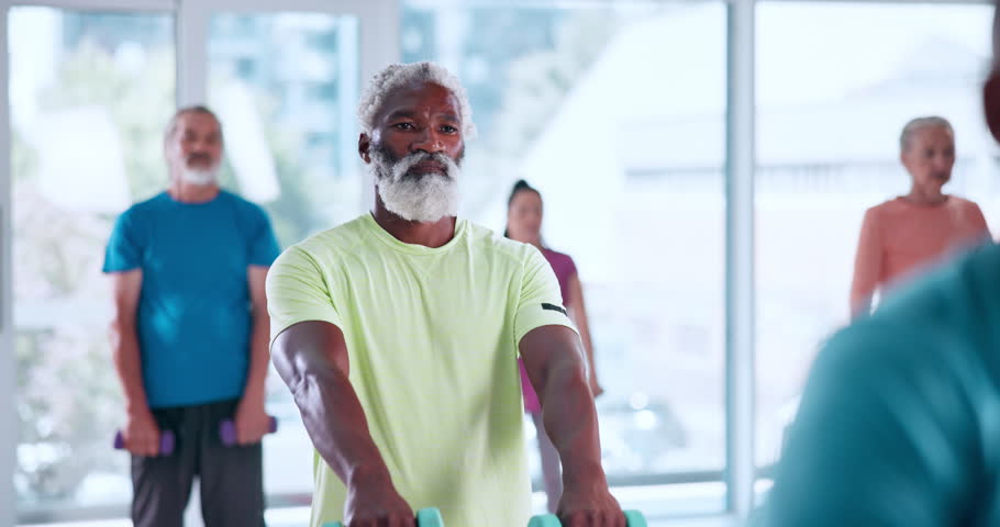 Exercise, senior man and dumbbells in class for retirement fitness, functional strength and mobility. Pensioner wellness club, elderly people and weight training in studio for joint health or workout