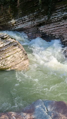 Powerful mountain river flowing through a rocky gorge creating white water rapids and a pristine natural environment