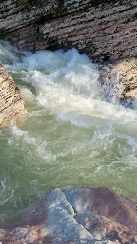 Powerful mountain river flowing through a rocky gorge creating white water rapids and a pristine natural environment