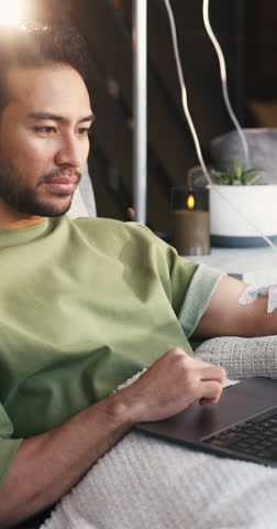 Laptop, iv infusion and man at clinic with relax for social media, research or reading blog. Technology, wellness and male person with computer for nutrition information with health at vitamin bar.