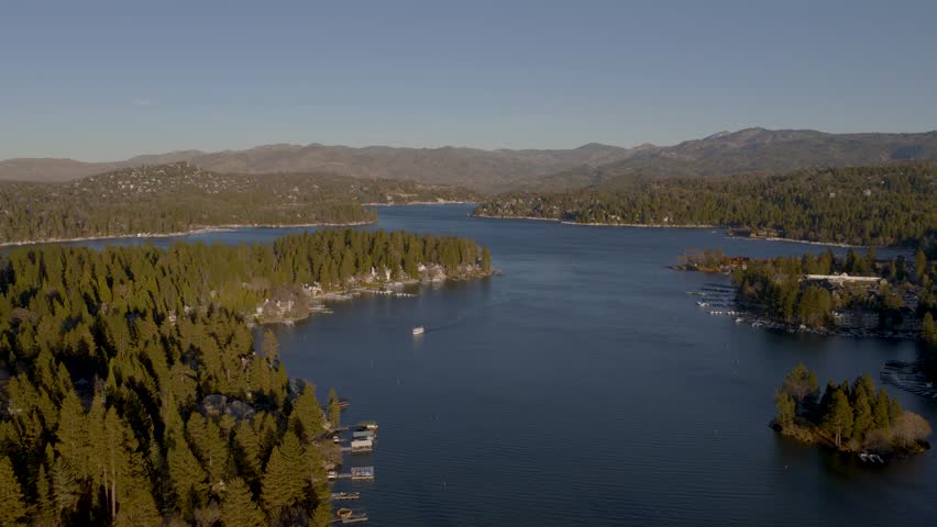 Drone shot sunset flying over Lake Arrowhead towards the mountains.
