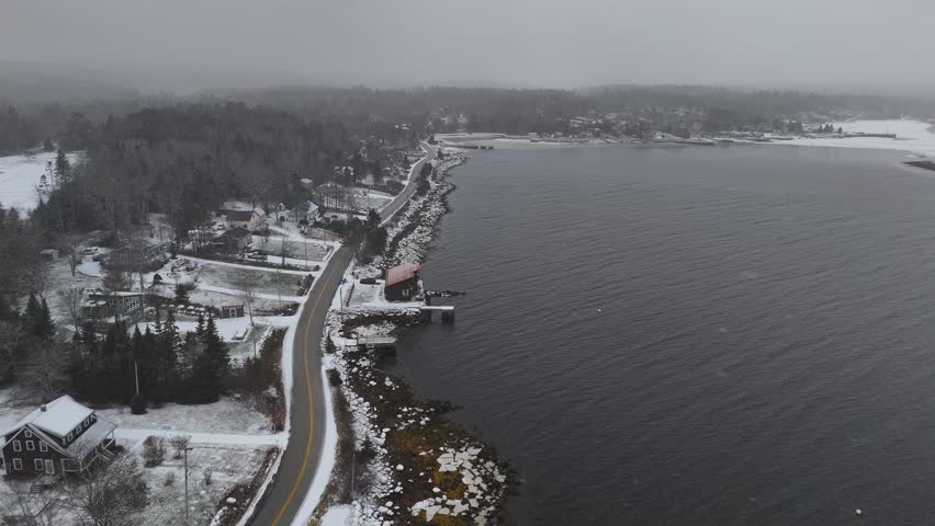 Fly over a waterfront road in Nova Scotia Canada during a winter snow storm
