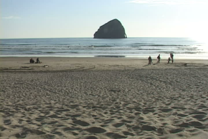 People enjoy beach setting around Cape Kiwanda, in Oregon.