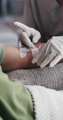 Doctor, hands or injection with IV drip for blood infusion, vitamins or immune booster in clinic. Closeup, people or nurse helping patient with needle prep for detox, nutrition or healthcare recovery