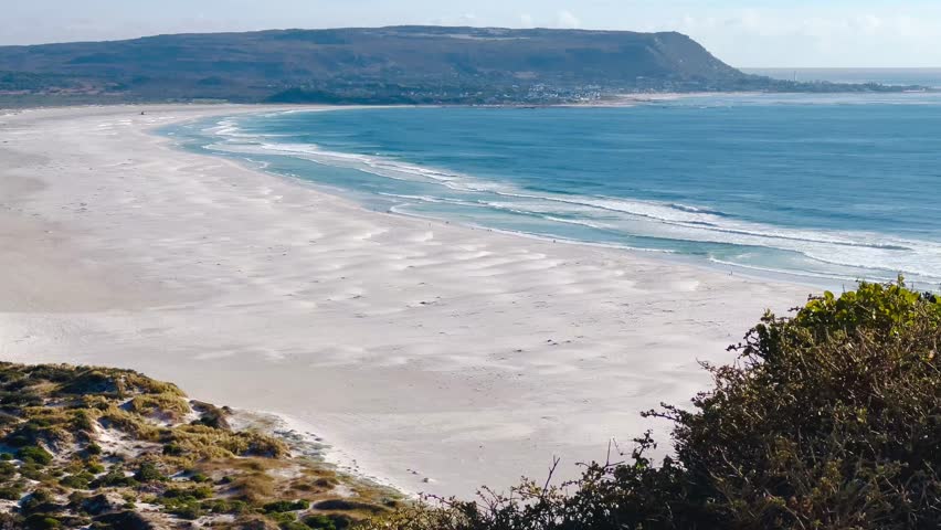 Aerial views of the Cape Peninsula in South Africa featuring dramatic Atlantic coastline, Chapman’s Peak Drive, Noordhoek Beach, Cape Point and the Cape of Good Hope. The footage showcases rugged cliffs, white sand beaches, turquoise ocean water and rolling mountains within Table Mountain National Park.

Filmed in bright summer daylight, the video captures scenic coastal roads, panoramic viewpoints, coastal fynbos vegetation and powerful waves meeting rocky shorelines. This iconic region at the southwestern edge of the African continent is known for its biodiversity, unspoiled landscapes and spectacular seascapes, making it ideal for travel, tourism, nature and adventure productions.