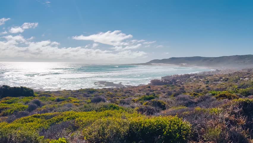 Aerial views of the Cape Peninsula in South Africa featuring dramatic Atlantic coastline, Chapman’s Peak Drive, Noordhoek Beach, Cape Point and the Cape of Good Hope. The footage showcases rugged cliffs, white sand beaches, turquoise ocean water and rolling mountains within Table Mountain National Park.

Filmed in bright summer daylight, the video captures scenic coastal roads, panoramic viewpoints, coastal fynbos vegetation and powerful waves meeting rocky shorelines. This iconic region at the southwestern edge of the African continent is known for its biodiversity, unspoiled landscapes and spectacular seascapes, making it ideal for travel, tourism, nature and adventure productions.