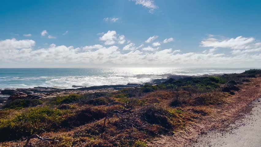 Aerial views of the Cape Peninsula in South Africa featuring dramatic Atlantic coastline, Chapman’s Peak Drive, Noordhoek Beach, Cape Point and the Cape of Good Hope. The footage showcases rugged cliffs, white sand beaches, turquoise ocean water and rolling mountains within Table Mountain National Park.

Filmed in bright summer daylight, the video captures scenic coastal roads, panoramic viewpoints, coastal fynbos vegetation and powerful waves meeting rocky shorelines. This iconic region at the southwestern edge of the African continent is known for its biodiversity, unspoiled landscapes and spectacular seascapes, making it ideal for travel, tourism, nature and adventure productions.