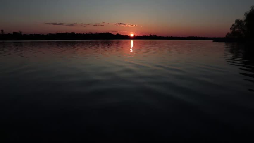 Sunset over calm lake with reflection