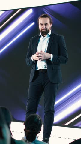Vertical Video Male CEO presenting new mobile phone product launch on stage with premiere of modern smartphone interface. Entrepreneur introduces innovation and development with product release