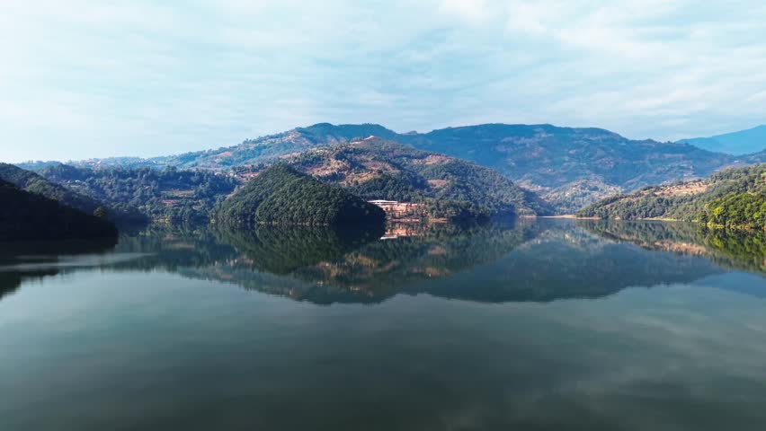 Serene lake landscape with lush green mountains reflecting on calm water