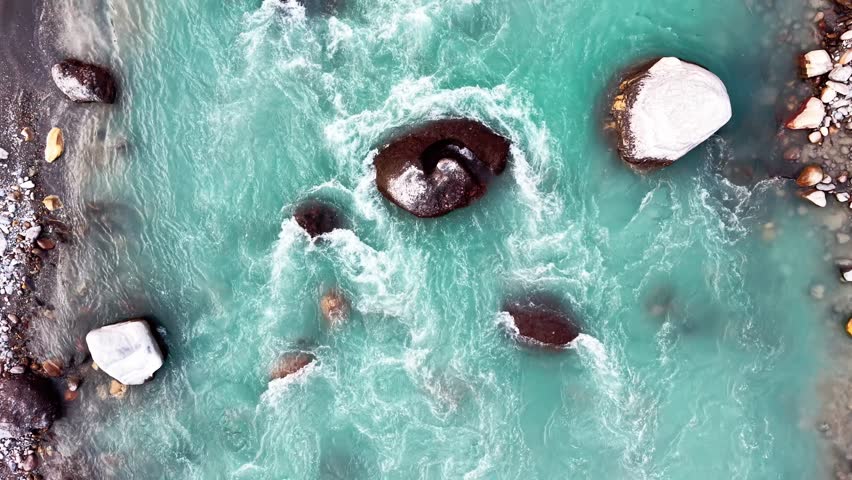 Turquoise river flowing over rocks in natural landscape