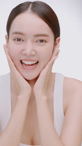 Vertical clip. Portrait of a young Asian girl with light makeup and perfect skin. Beautiful face of young woman with natural skin.