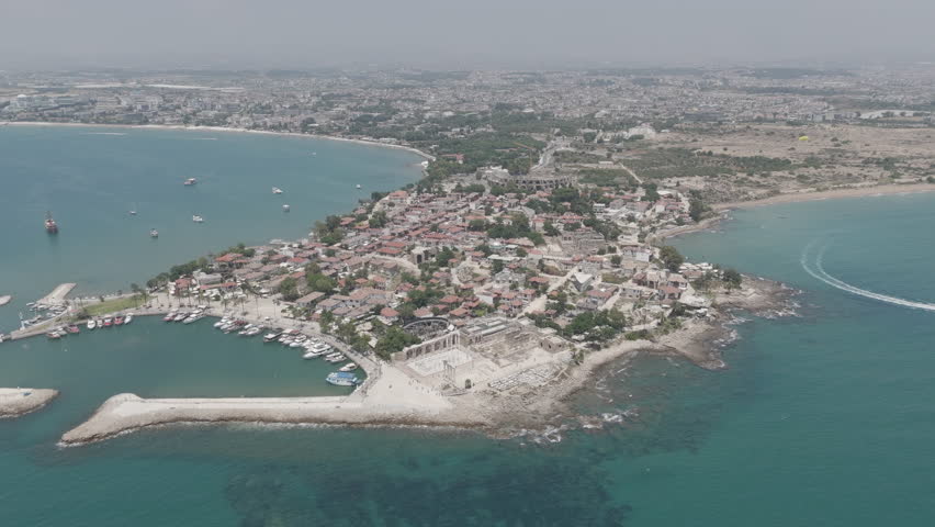 Side, Manavgat, Turkey. Historic peninsula with ancient ruins along Mediterranean shore, aerial view in summer daylight, archaeological landscape. D-Log M. Aerial View, Spiral forward