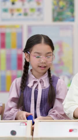 Curious schoolgirl experiments with colorful magnets during hands-on STEM activity in bright classroom