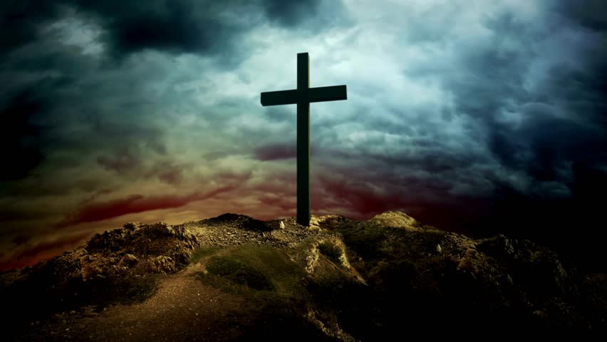 Cross on Hill in Silhouette at Sunset. Dramatic clouds roll overhead. Represents Christianity, faith, religion, hope. Powerful and inspiring religious symbol on hill