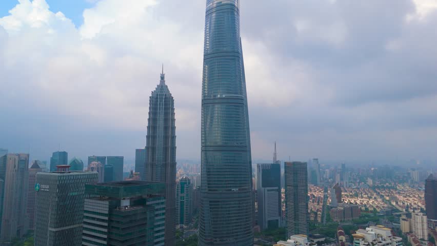 Aerial shot of the Shanghai Tower and Jin Mao Tower standing among dense urban buildings in the financial district of Shanghai, China.