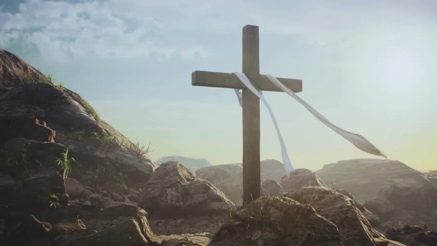 Wooden cross adorned with white cloth stands amidst rocky terrain, illuminated by gentle sunlight. Tranquil atmosphere embodies faith and spirituality in nature.