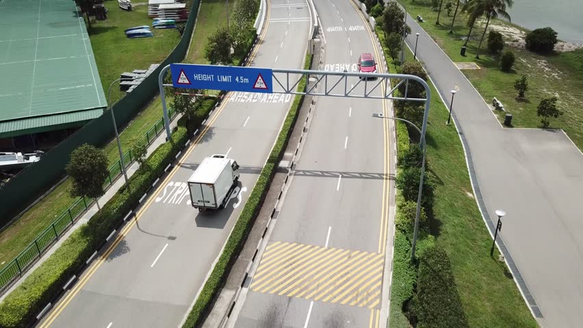 Drone shot of white van driving on road near Kallang river (Singapore)