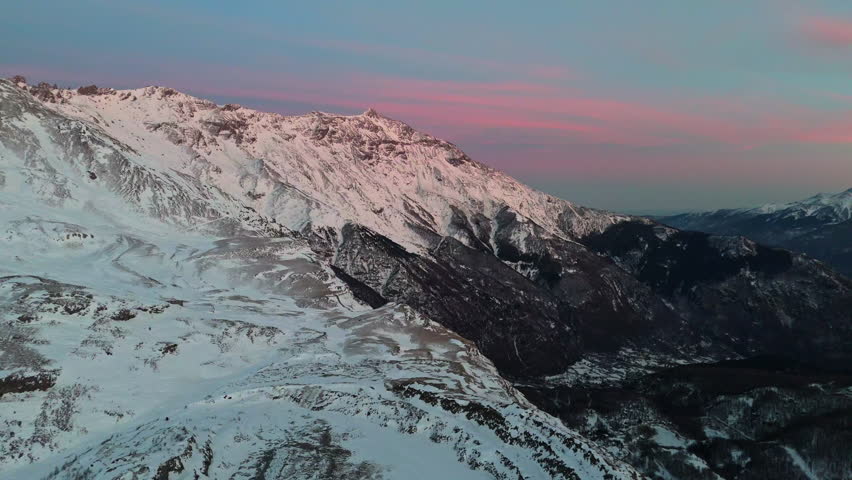 Snowy mountains at sunset create a serene winter landscape