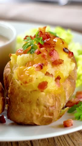  baked stuffed potato topped with melted cheese and crispy bacon. healthy eating. Vertical video for social media content