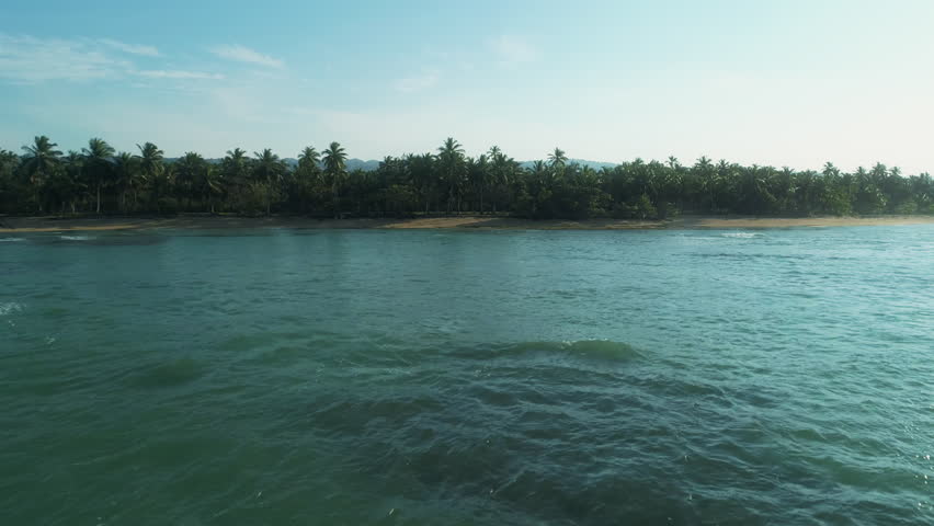 Drone flies from the sea toward a palm-lined beach along Panama’s coast