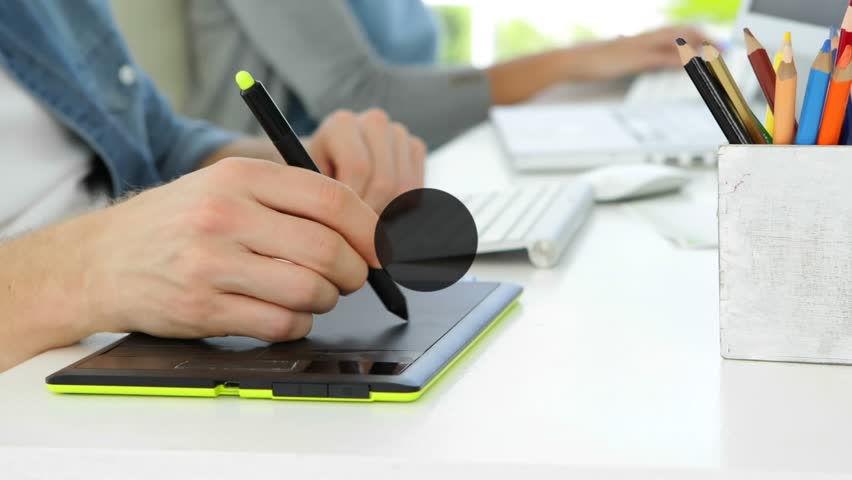 Animation of connected icons over midsection of caucasian man drawing on graphics tablet. Digital composite, multiple exposure, communication, business, office and technology concept.