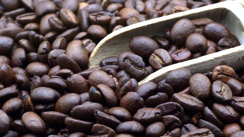 Macro shot of aromatic dark roasted coffee beans with wooden scoop, high-quality cinematic 4K food background for cafe branding