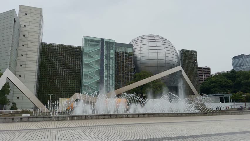 Water jets dancing in front of the modern architecture of the Nagoya City Science Museum in Japan