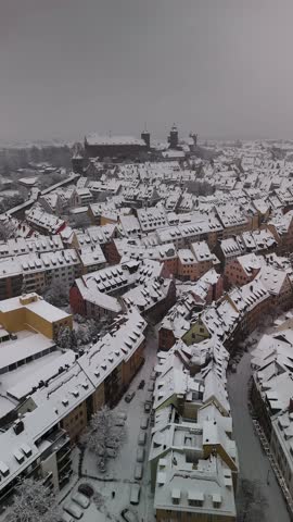 Aerial view on the imperial castle of Nuremberg in Germany covered in snow during winter. Historic half-timbered houses in the foreground. drone view.