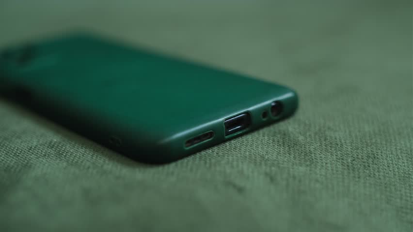 Mobile phone charging. Hands connecting smartphone to charger. Close up.