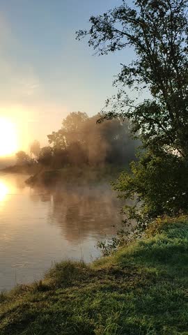 Misty morning on the river: beautiful sunrise with fog rising over the water.