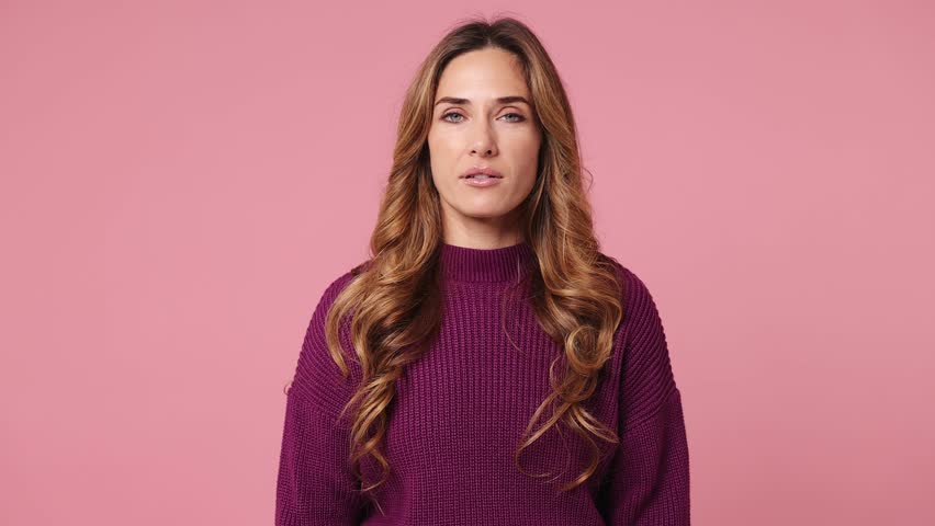 Happy fun young woman she wear purple knitted sweater casual clothes hold in hand fan of cash money in dollar banknotes doing winner gesture celebrate isolated on plain pastel light pink background