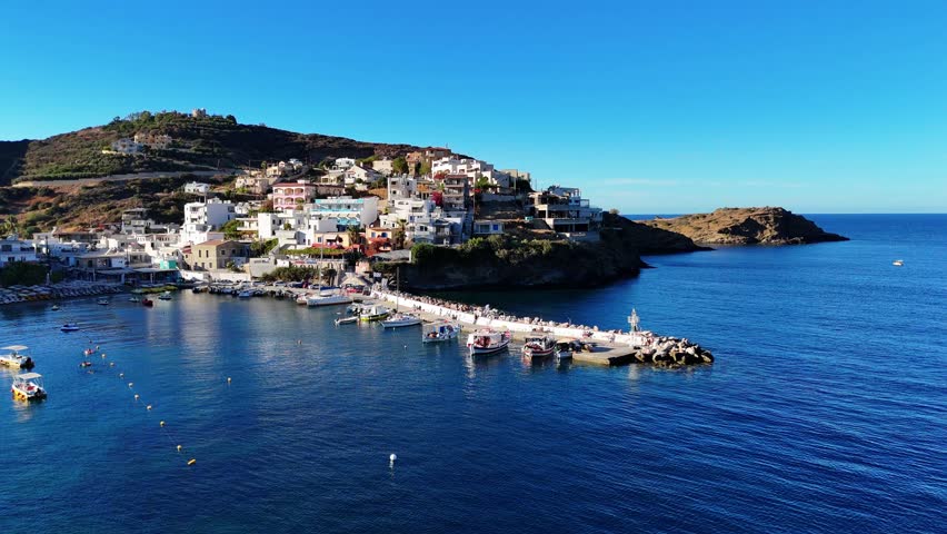 Aerial view of coastal landscape in Crete, Greece, featuring Mediterranean Sea, rocky shoreline and city scenery