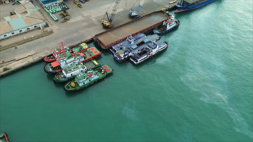 Aerial view of the busy port activity with various ships docked at the bustling port.