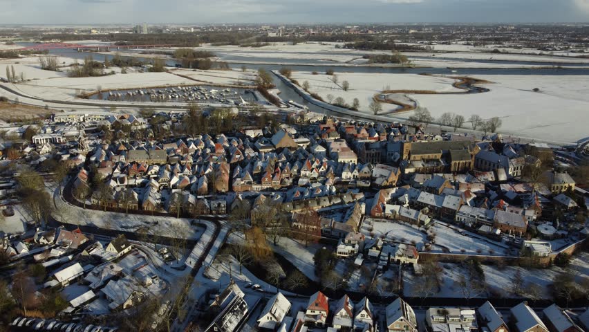 Hattem, the Netherlands - January 4th 2026: Aerial footage of a snow covered medieval city center. Winter time. 