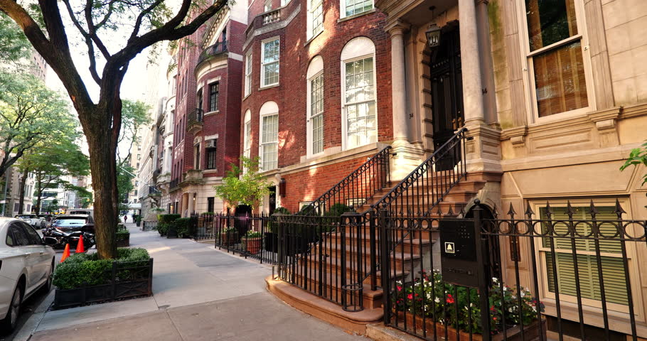 New York City brownstone residential homes in Manhattan with classic architecture tree lined street and stoops