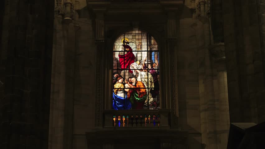Old stained glass windows in a dark church, saints, bible scenes, religious art decoration details.