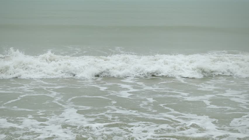 landscape view of heavy wave oceanic foam is coming to the beach while in storming heavy raining weather. aerial footage landscape and water waves with nobody. vacation outdoor landscape texture